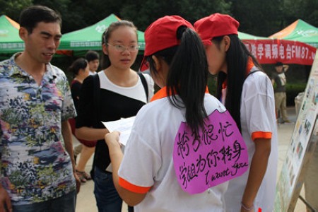 武汉东湖学院青年志愿者身背萌标语迎新-青